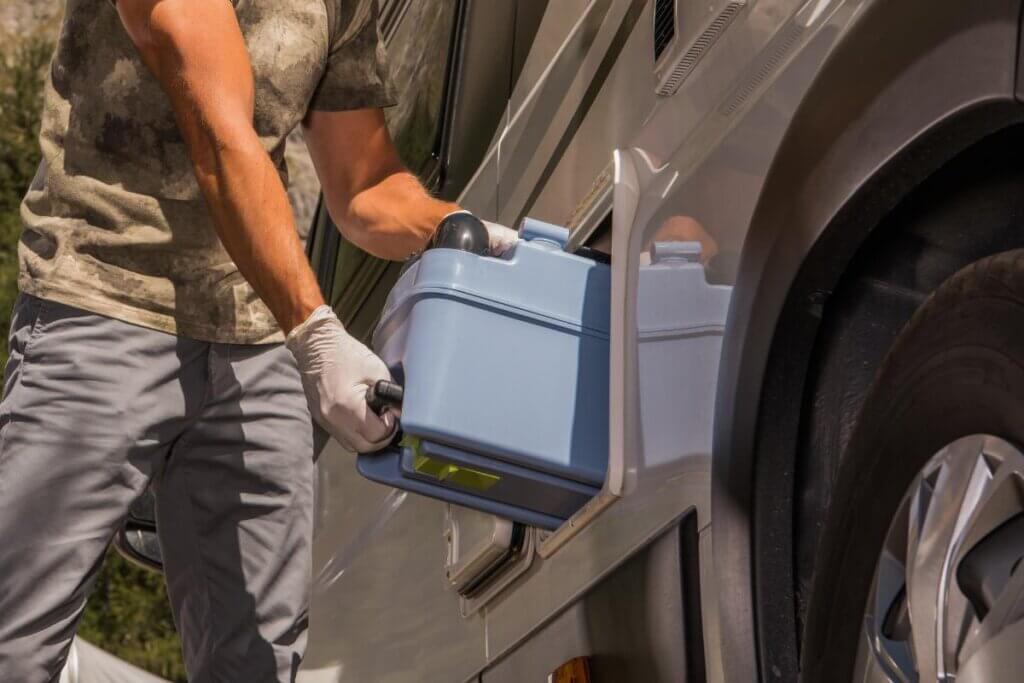 storing a blue camper van portable toilet on the side compartment of a van.