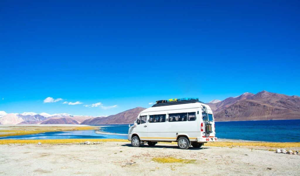 camper van on the beach with a ladder rack