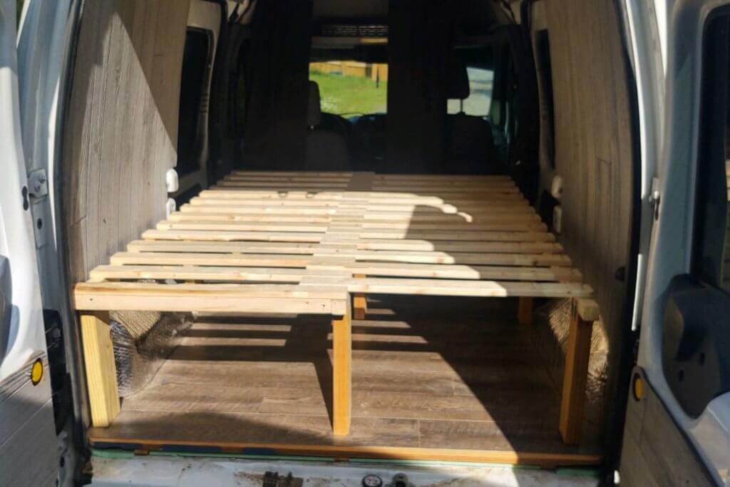 Pull out slat bed in the back of a camper van. in a small camper van, takes up the whole back cab.