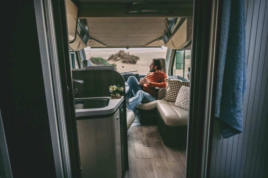 man sitting on a chair in the front cab of a camper