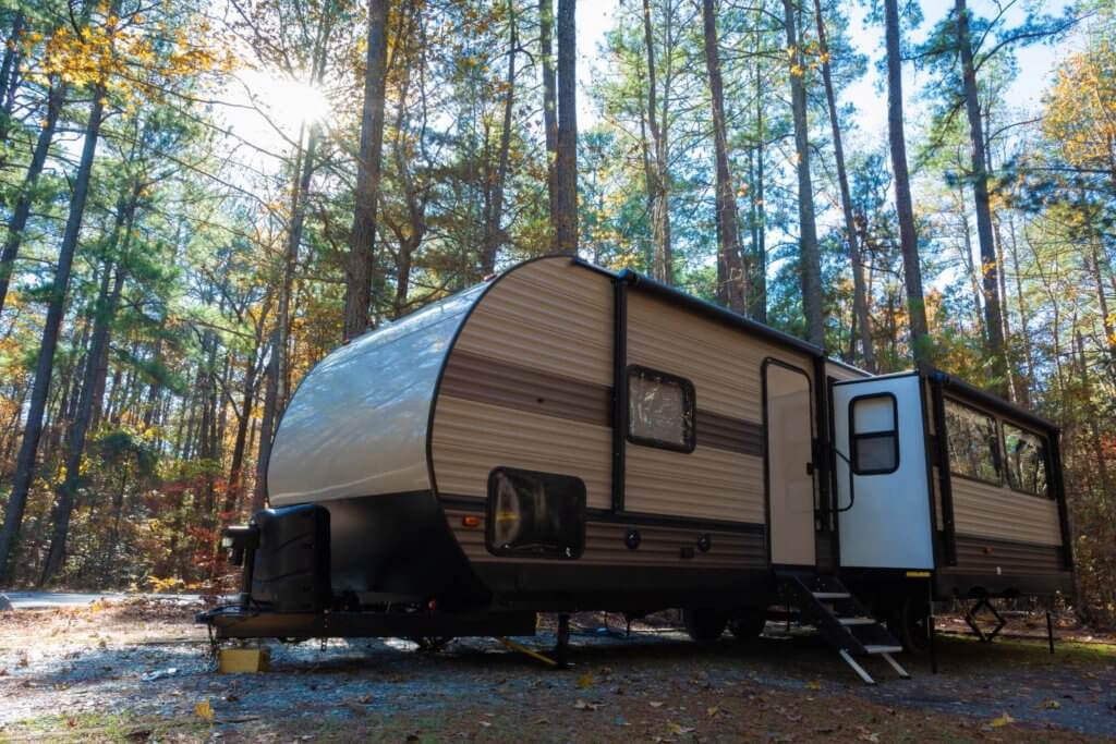 travel trailer surrounded by woods