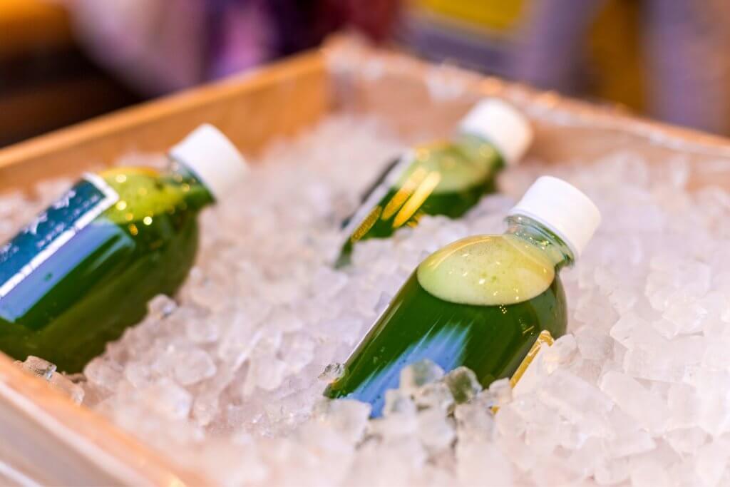 cooler filled with ice and green drinks