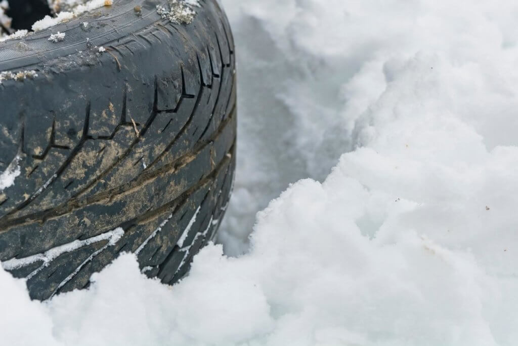 tire laying flat on ground in deep snow