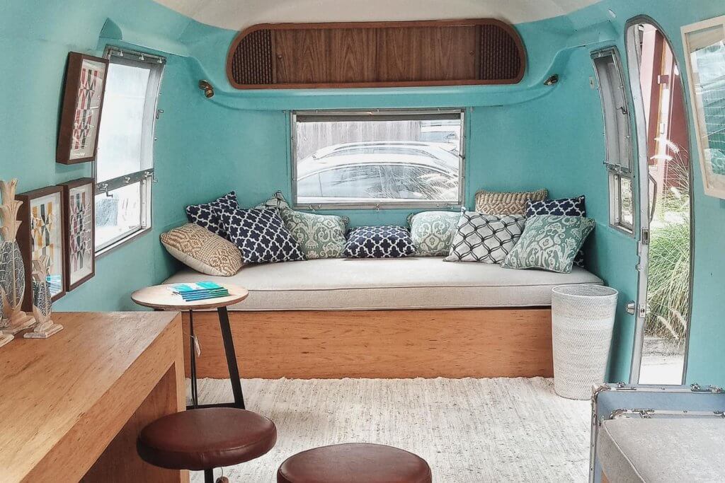 camper van couch with white cushion and blue throw pillows