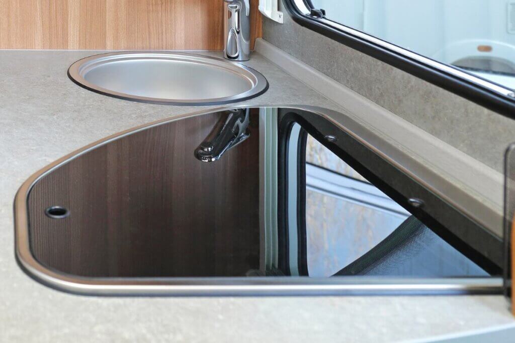 black glass stove cover next to a camper van sink