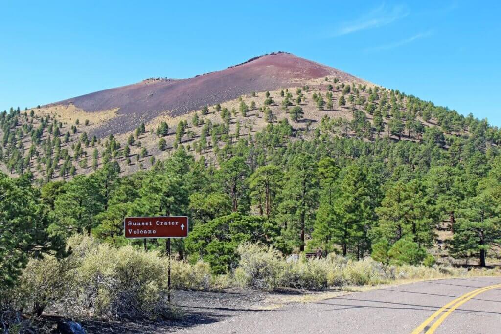 sunset crater with evergreen trees surrounding it.