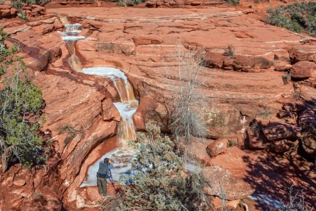 Line of pools with waterfalls in between them on red rock in Sedona