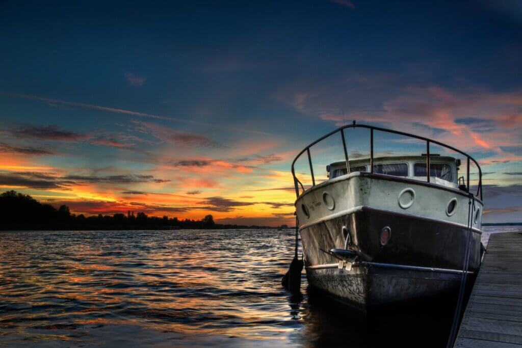 Boat on a lake at sunset. sunset is pretty orange and pink colors