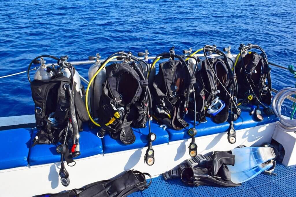 Scuba gear lined up on a boat in the water at Oak Island